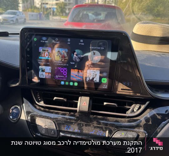 מערכת מולטימדיה ברכב עם מסך מגע ומבנים ברקע